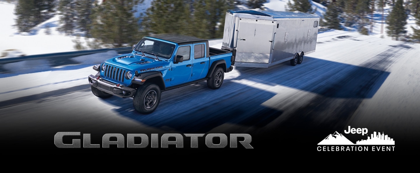 The 2022 Jeep Gladiator Rubicon towing an enclosed trailer on a snowy mountain road. The Jeep Celebration event logo.